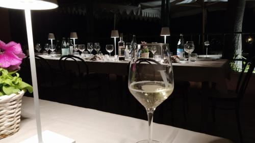 a glass of white wine sitting on a table at Hotel Ristorante alla Campagna in San Giovanni Lupatoto