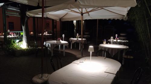 a group of tables with white umbrellas at Hotel Ristorante alla Campagna in San Giovanni Lupatoto