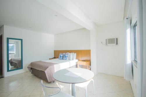 a hotel room with a bed and a table and chairs at Ilha Porchat Hotel in São Vicente