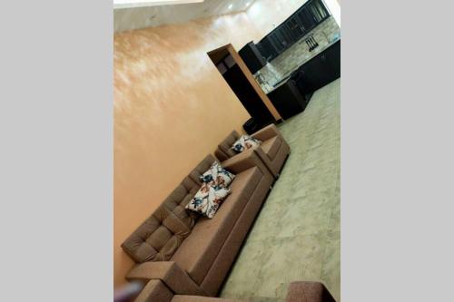 two people sitting on a couch in a living room at Heavenly ApHEARTment with backyard swimming pool in Dodoma