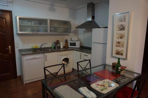 a small kitchen with a table and a counter top at Apartamento Faro de Tapia in Tapia de Casariego