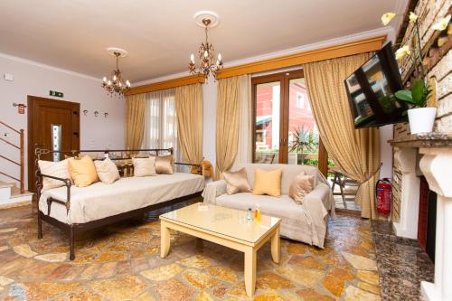 a living room with two couches and a fireplace at Medusa's Villas in Acharavi