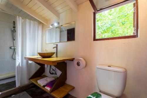 baño con aseo y lavabo y ventana en Beach Studio Aerial at Lac Bay en Kralendijk