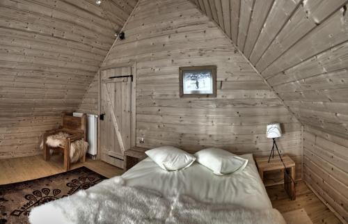 um quarto com uma cama num quarto de madeira em Szymkówka em Bukowina Tatrzańska