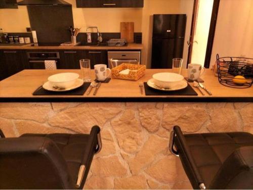 a kitchen counter with a table with plates and glasses at Magnifique Villa a Tourbes proche du Cap d Agde in Tourbes