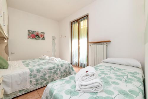 1 Schlafzimmer mit 2 Betten und einem Fenster in der Unterkunft Bell'Italia Holiday Apartment Peschiera in Peschiera del Garda