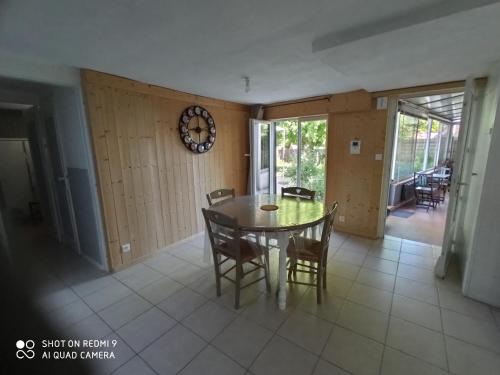 une salle à manger avec une table, des chaises et une horloge dans l'établissement La Providence, à Chaumont