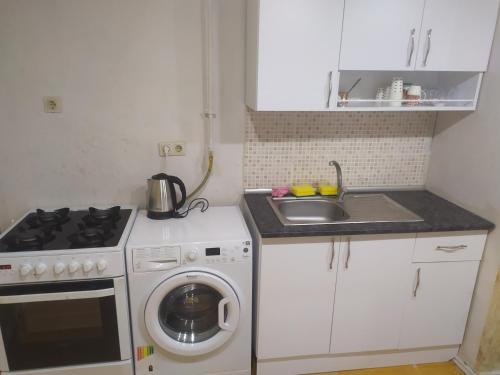 een kleine keuken met een wasmachine en een wastafel bij Üsküdar home in Istanbul