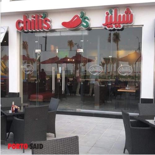 a restaurant with tables and chairs in front of a window at porto said بورتوسعيد in `Ezbet Shalabi el-Rûdi