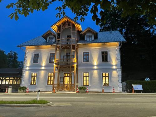 a large white building with a balcony on a street at Hotel Starkl - Heritage & Unique in Bled