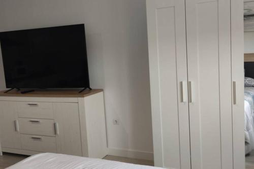 ein Schlafzimmer mit einem TV und einem weißen Schrank in der Unterkunft Apartamentos NayDa Studio 2 in Merida