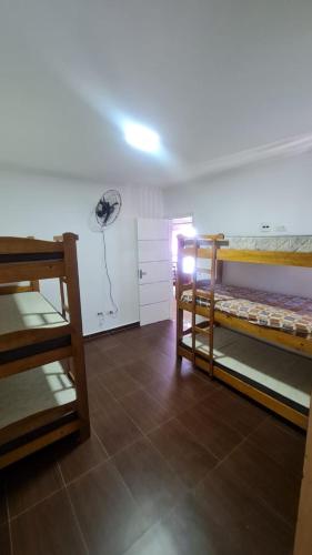 a room with two bunk beds and a fan at Apartamento De Alto Padrão - Ocian in Praia Grande