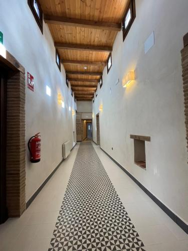 a hallway with a tile floor and a wooden ceiling at APARTAMENTOS RURALES POSADA DE LLERENA in Llerena