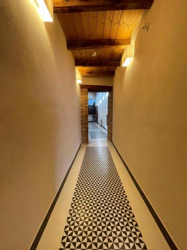 a hallway with a black and white tile floor at APARTAMENTOS RURALES POSADA DE LLERENA in Llerena