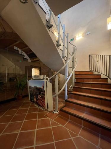 a staircase in a building with brown tile floors and a stair case at APARTAMENTOS RURALES POSADA DE LLERENA in Llerena