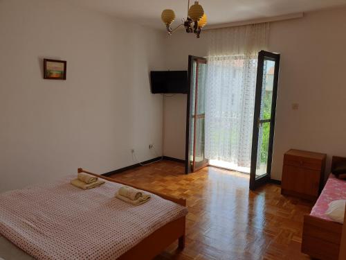 una camera da letto con due letti e una grande finestra di Assato Retro Apartment a Vodice