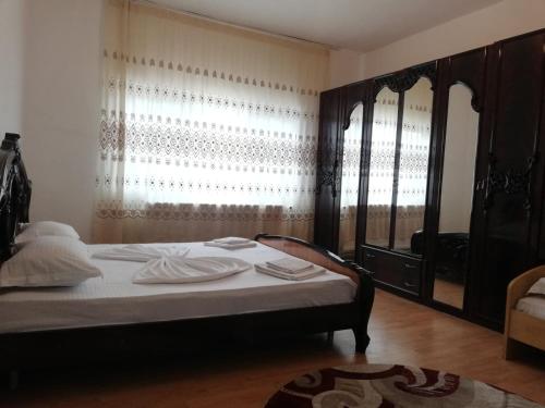 a bedroom with a bed and a large window at Red House in Orşova