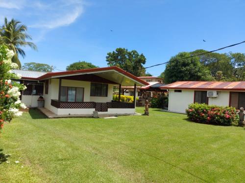 a house with a green lawn in front of it at Yubarta Lodge in Uvita
