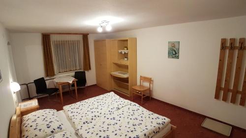 a small bedroom with two beds and a table and chairs at Haus Christof in Holzgau