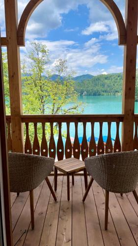 a porch with two chairs and a table and a view of a lake at Hotel Starkl - Heritage & Unique in Bled