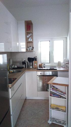 eine Küche mit weißen Schränken und einer Arbeitsplatte in der Unterkunft Swiss holiday 4 in Split