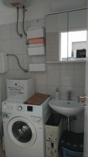 a bathroom with a washing machine and a sink at Swiss holiday 4 in Split