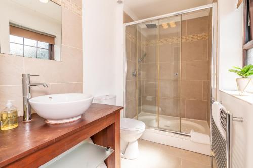 a bathroom with a sink and a shower at MK City Center House, perfect for FAMILIES, GROUPS, free parking, Sky TV, Desk space managed by CHIQUE PROPERTIES LTD in Milton Keynes