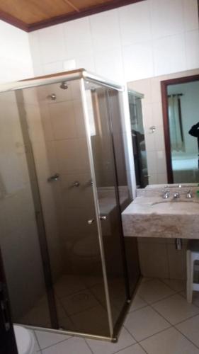 a bathroom with a shower and a sink at Hotel Monte Carlo in Campos do Jordão