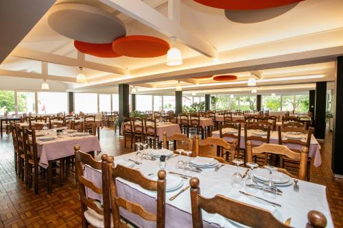 a restaurant with tables and chairs in a room at Hotel Restaurant Bonnet in Saint-Pée-sur-Nivelle