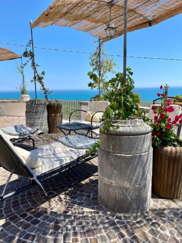 a patio with a bed and chairs and an umbrella at Villa in Gargano - VILLA BASSO in Monte SantʼAngelo