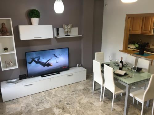 sala de estar con TV y mesa con sillas en RUIDERA HOLIDAY, en Ruidera