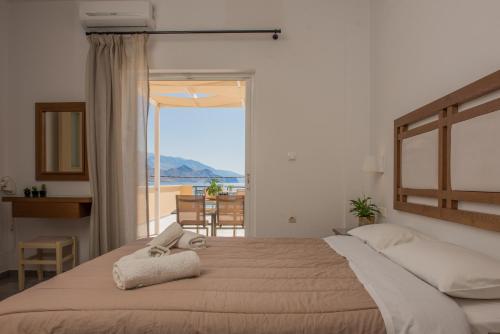 a bedroom with a bed with a view of the ocean at Harbour Studios And Apartments in Palaiochóra