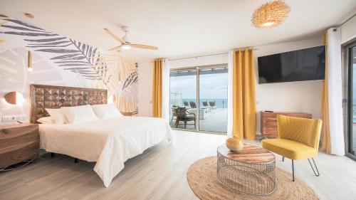 a bedroom with a bed and a television and a chair at Etti - Paradise Suite La Gaviota in Pájara