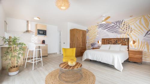 a bedroom with a bed and a table and a kitchen at Etti - Paradise Suite La Gaviota in Pájara