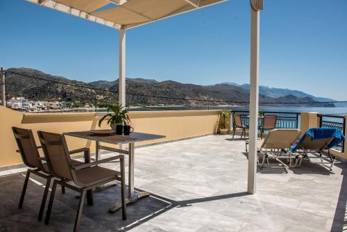 a patio with chairs and a table on a balcony at Harbour Studios And Apartments in Palaiochóra
