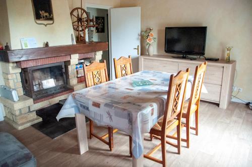 une salle à manger avec une table et une cheminée dans l'établissement Le chalet de CLEM & SAND, à Saint-Riquier-ès-Plains