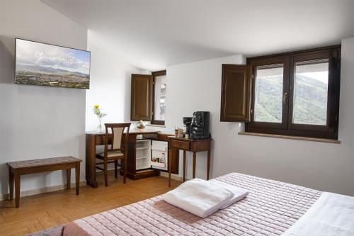 a bedroom with a bed and a desk and a kitchen at Green Park in Corbara