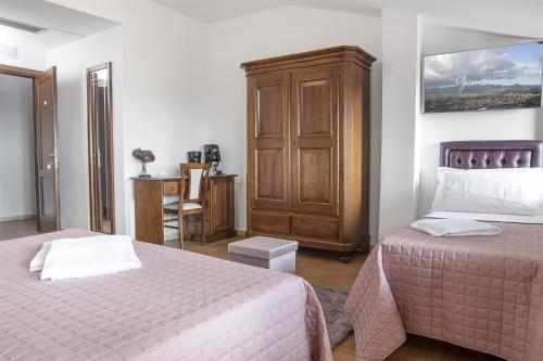 a bedroom with two beds and a wooden cabinet at Green Park in Corbara