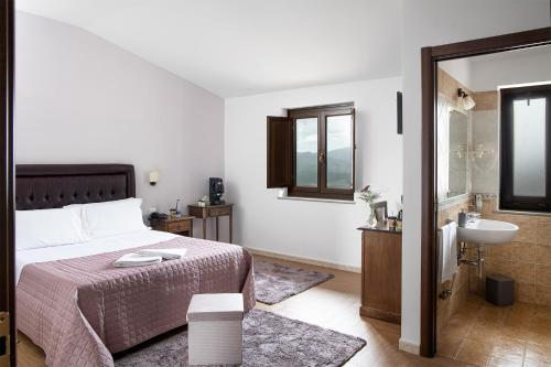 Schlafzimmer mit einem Bett, einem Waschbecken und einem Spiegel in der Unterkunft Green Park in Corbara