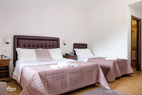a bedroom with two beds with pink and white sheets at Green Park in Corbara