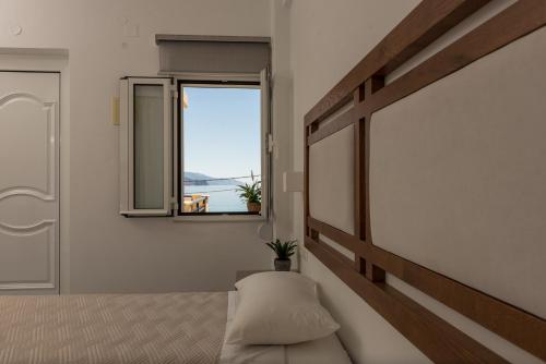 a bedroom with a bed and a window at Harbour Studios And Apartments in Palaiochóra