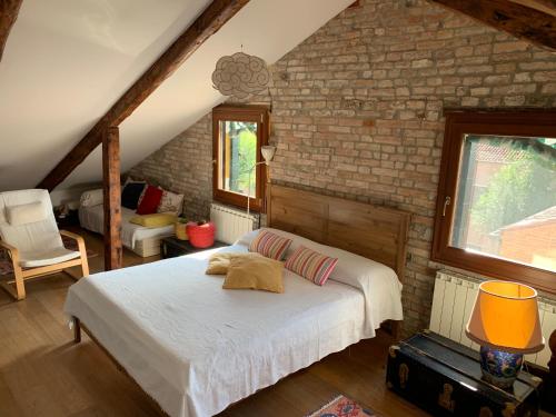 een slaapkamer met een bed en een bakstenen muur bij La Casa Del Pittore in Venetië