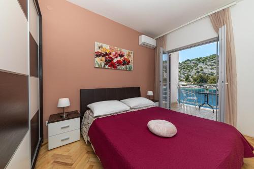 a bedroom with a large bed with a large window at Villa Antonija 1607 in Ražanj