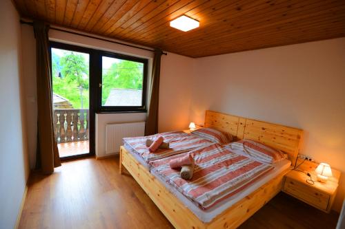 a bedroom with a bed and a large window at Apartmaji Pekovec Bohinj in Bohinj