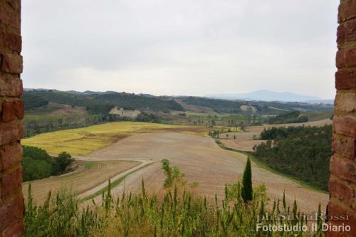 a view of a field from a castle window at San Lorenzo Agriturismo in Buonconvento