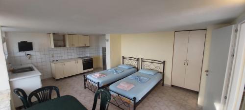 a small room with two beds and a kitchen at Magic Ionian Apartments & Rooms in Himare
