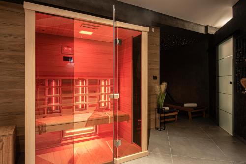 a glass shower door in a room with red walls at Exclusive Pula City Apartments in Pula