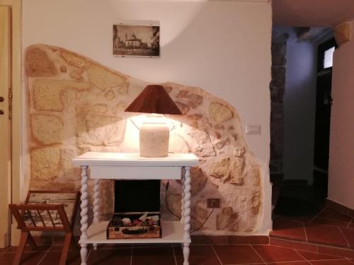 a table with a lamp on top of a fireplace at Casa Cossu in Sorso