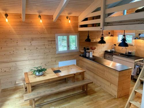 eine Küche mit Holzwänden und einem Holztisch in der Unterkunft Chalet des Bruyeres in Lans-en-Vercors