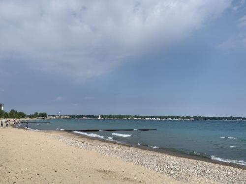 a beach with people walking on the sand and the water at Days Inn by Wyndham Sarnia Harbourfront in Sarnia